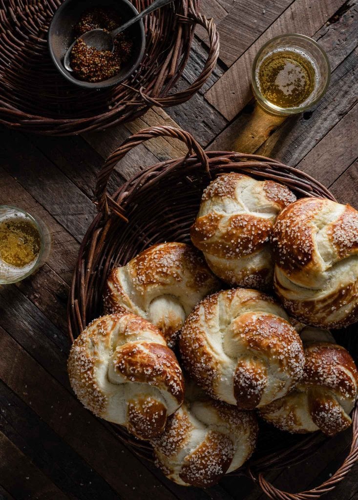 Basket of pretzel knots on table with two beers.