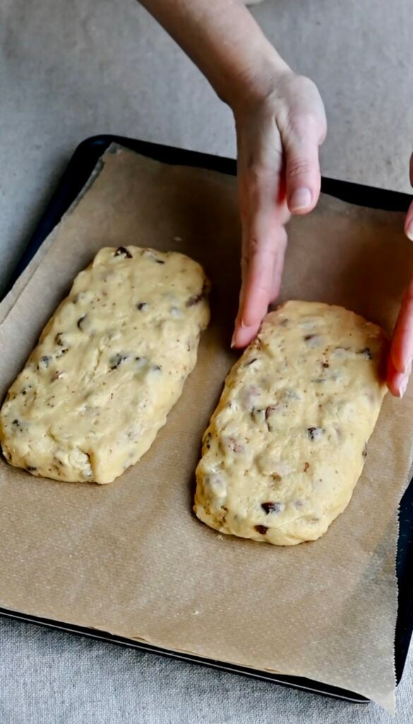 Two logs of biscotti dough on a parchment paper lined tray.