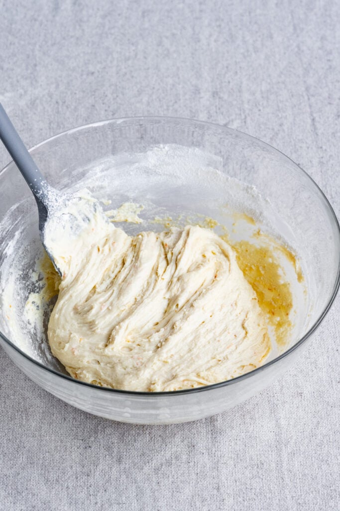 Biscotti dough in a large bowl with a silicone spatula.