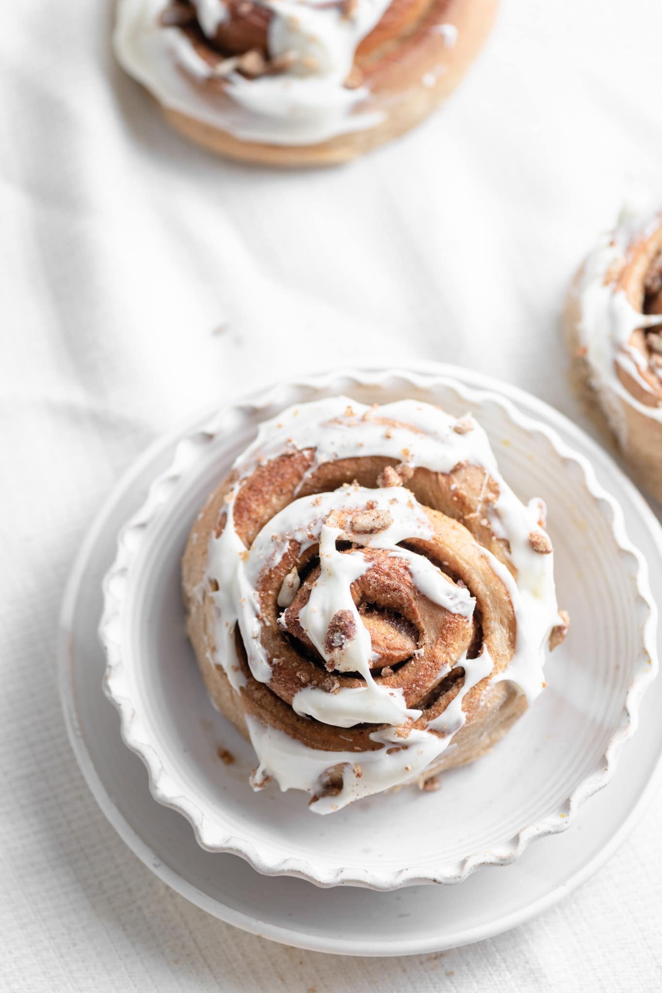 cream cheese frosted cinnamon roll with candied pecans