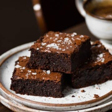 Stack of three brownies on a plate.
