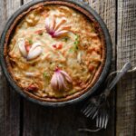 Onion tart in a pan with forks on table.