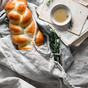 Braided loaf of bread wrapped in linen.