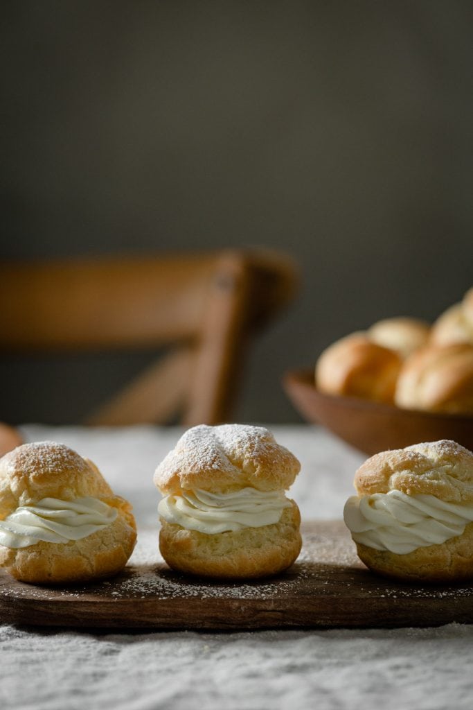 Banana cream filled choux pastry on cutting board.