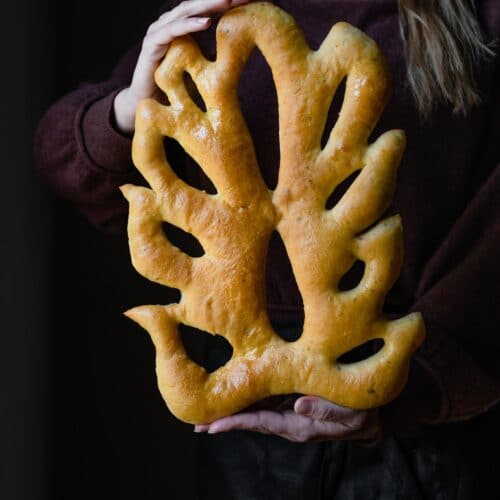 Lady holding a wheat shaped fougasse bread.