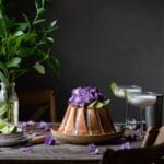 Key Lime Cake on table with flowers and cocktails.