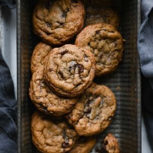 Stack of cookies inside a baking loaf an on blue apron.