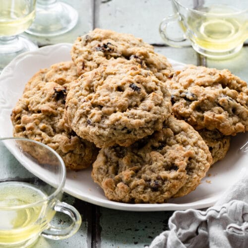 Oatmeal cookies stacked on a white plate.