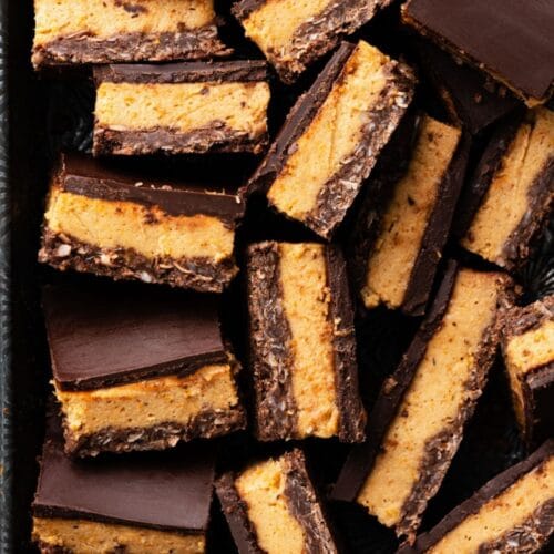 Close up of sliced chocolate and persimmon layer bars in a metal pan.