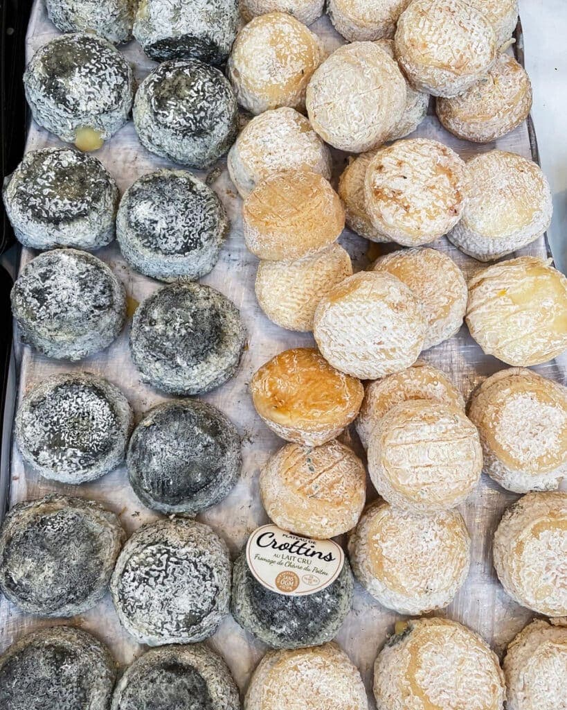 Small rounds of cheese on a market table.