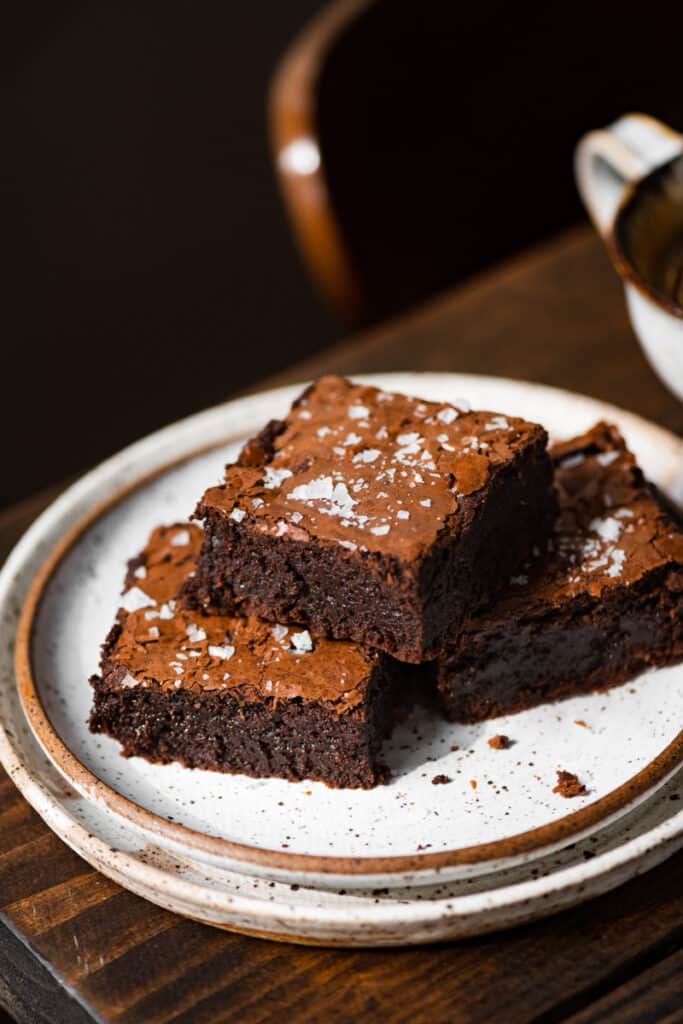 Salted brownies stacked on a plate.