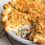 Looking into a chicken pie with a slice missing to show the creamy vegetable filling.