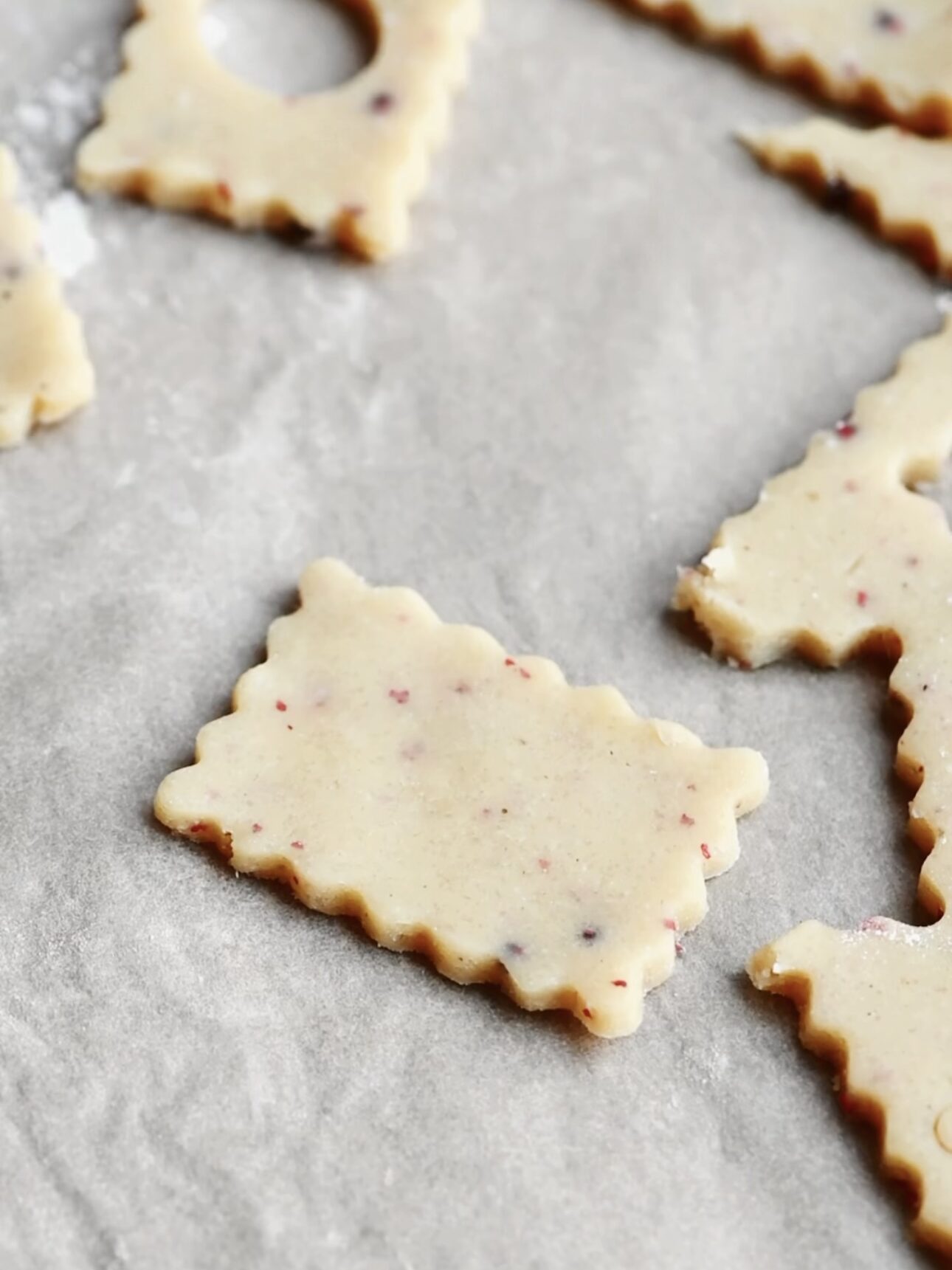 A piece of cookie dough cut out into a scalloped edge rectangle.