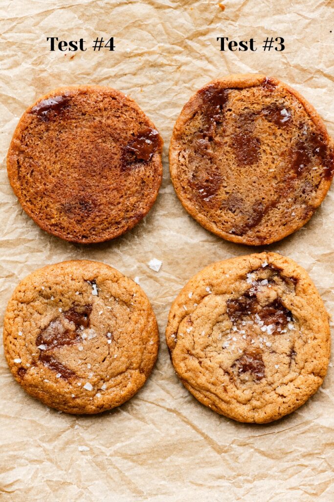 Two upside down cookies and two right site up cookies filled with toffee chunks on a baking sheet.