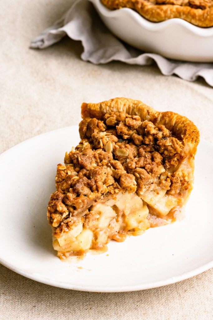 Slice of apple crumble pie on a plate.