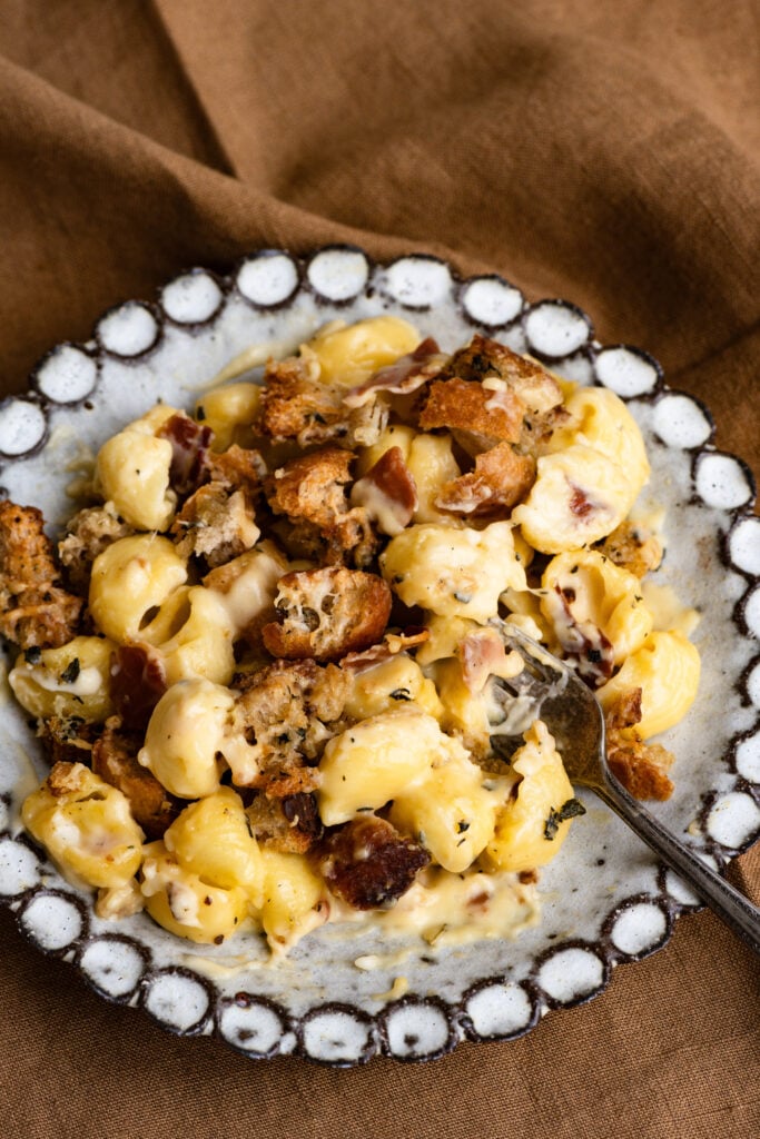 Mac and cheese casserole on a plate with a fork.