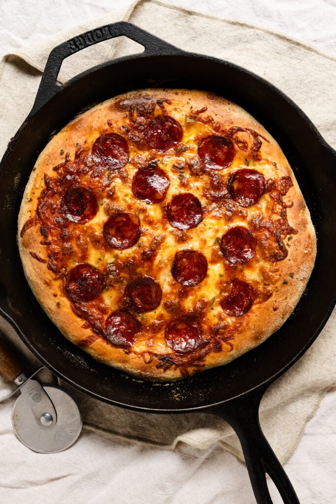 Overhead of a pepperoni pizza in a cast iron skillet.