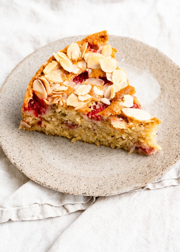 Slice of almond strawberry cake on a plate. 