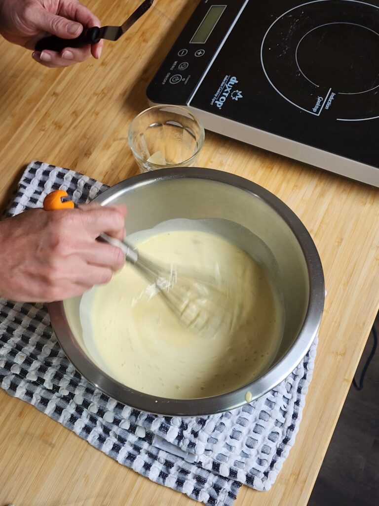 Gelatin being whisked into creme anglaise.