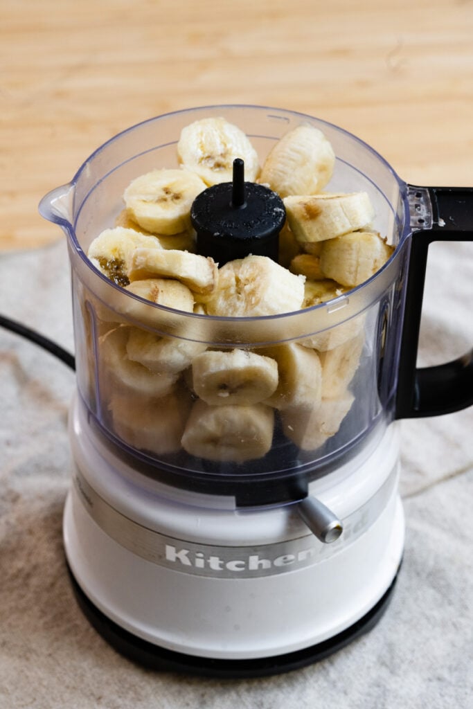 Sliced bananas in a mini food processor.