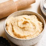 Bowl of French almond cream next to a rolling pin and tart pan.