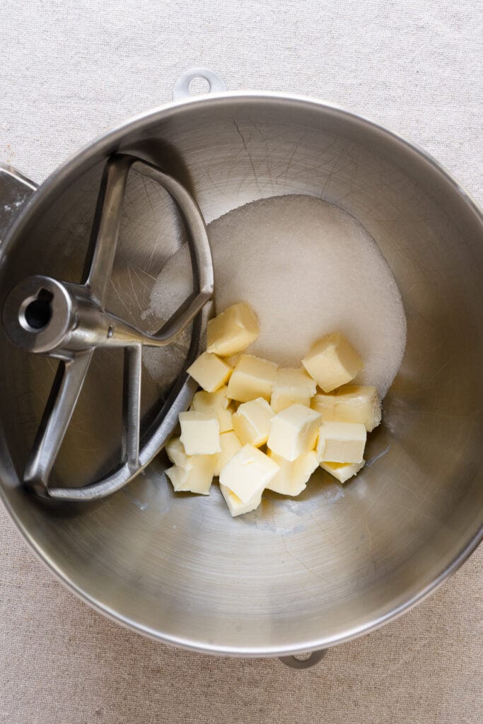 Cubes of butter and sugar in a mixing bowl with paddle attachment.