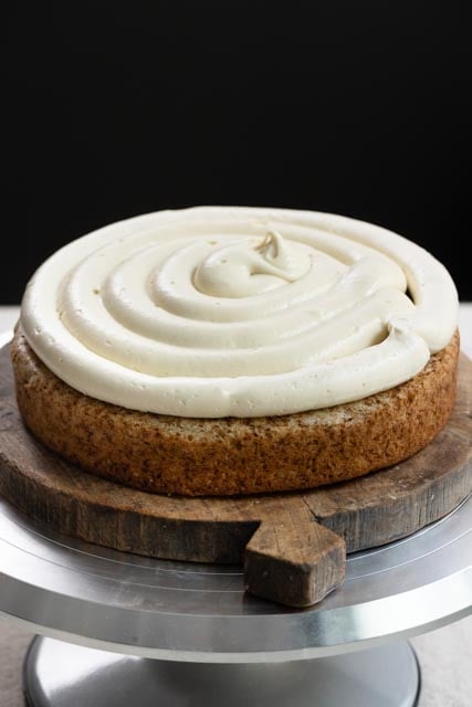 Single layer of banana cake on turntable, topped with frosting and banana cream filling.