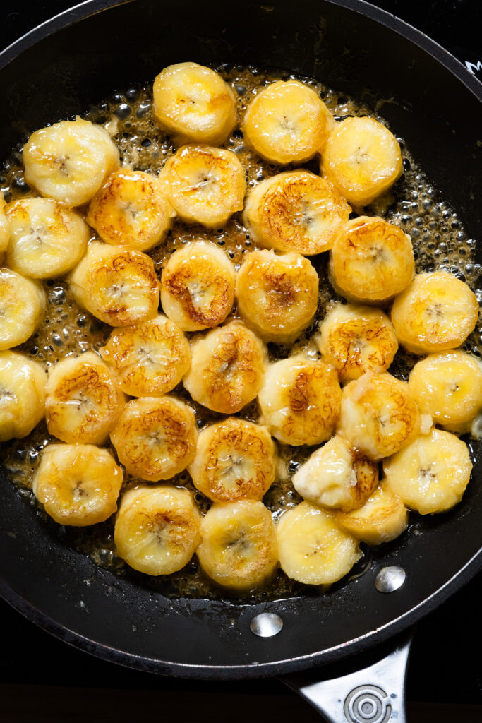 Caramelized bananas cooking in a skillet.