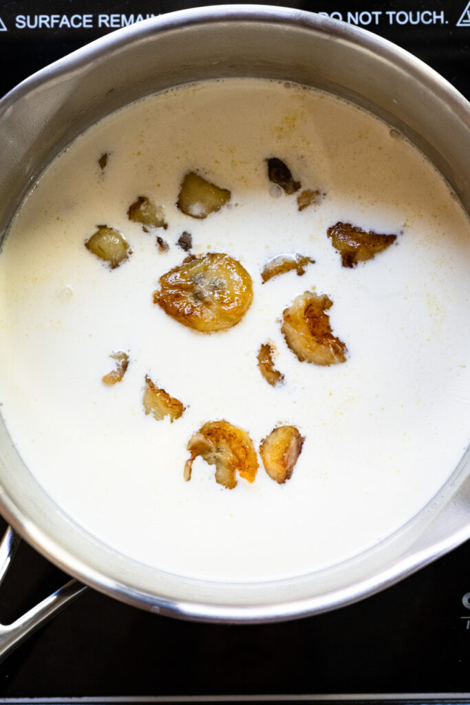 Caramelized bananas soaking in a pot of cream.