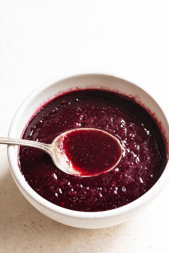 Cherry puree in a bowl with a spoon.