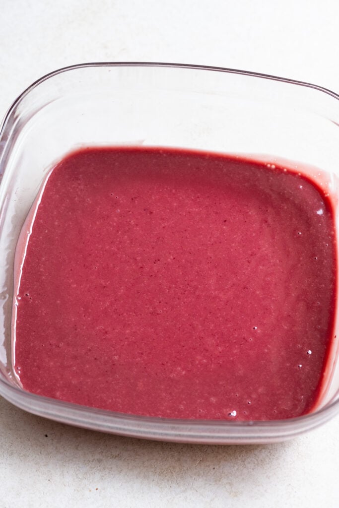 Liquid raspberry ganache in a glass bowl.