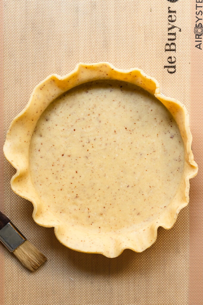 Overhead of tart dough placed inside a tart ring.