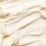 Honey swiss meringue buttercream frosting spread with a spatula.