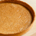 Baked pate sucree tart shell on a baking mat.