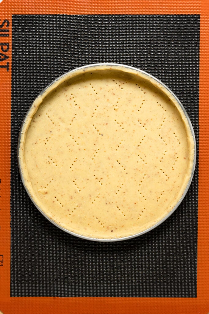 Overhead of unbaked pastry crust inside a pastry ring.
