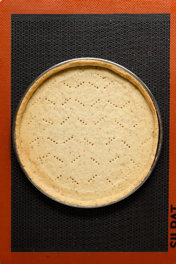 Overhead of a par-baked tart shell on a baking pan.