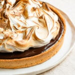 Closeup of a chocolate s'mores tart topped with toasted marshmallow meringue.