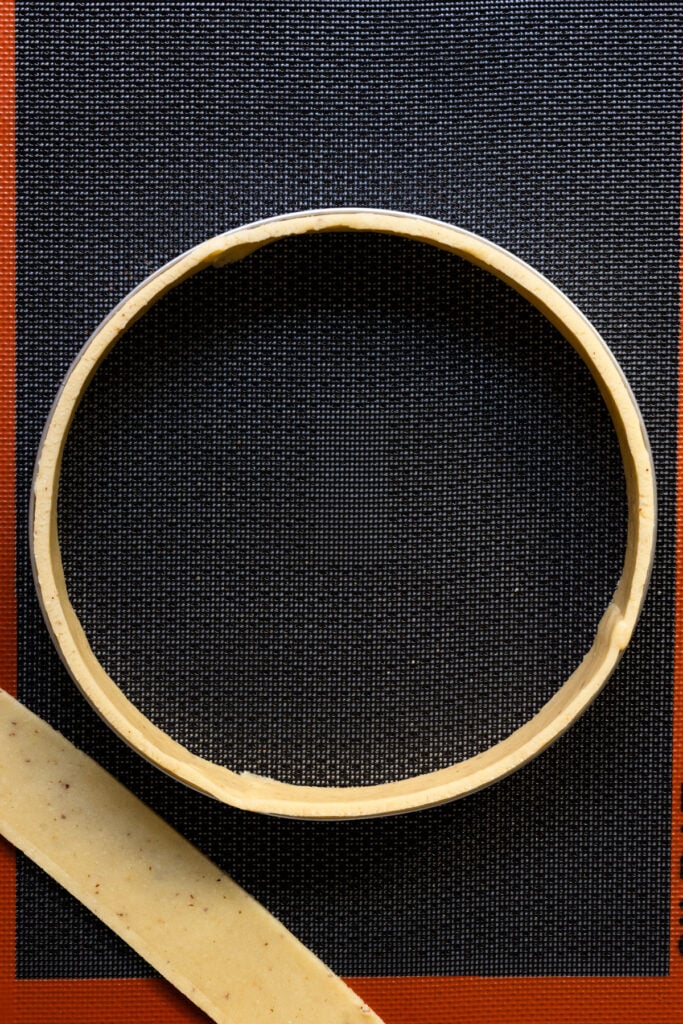 Overhead of a tart ring lined with pastry dough.
