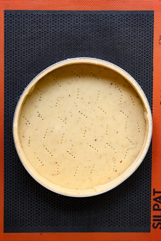 Overhead of pastry dough lined tart ring.