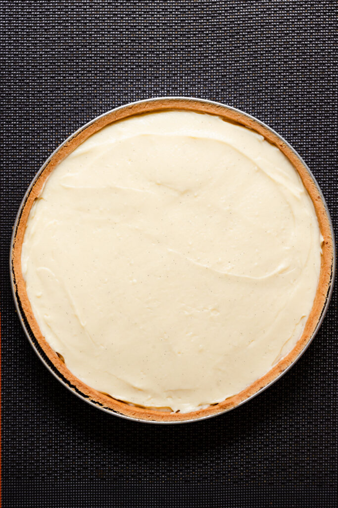Overhead of a tart shell filled with unbaked pastry cream.