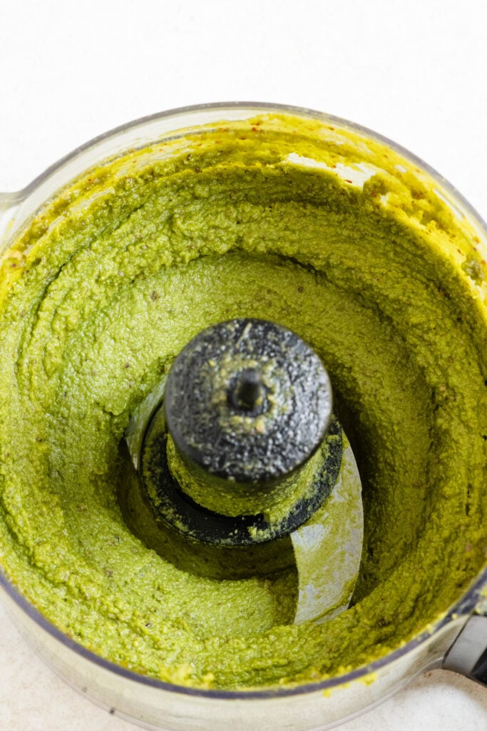 Creamy pistachio paste inside a food processor.
