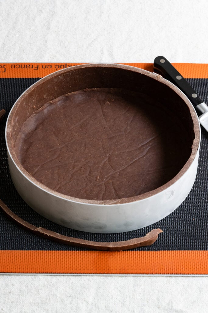 Frozen chocolate tart crust with the edges trimmed away.