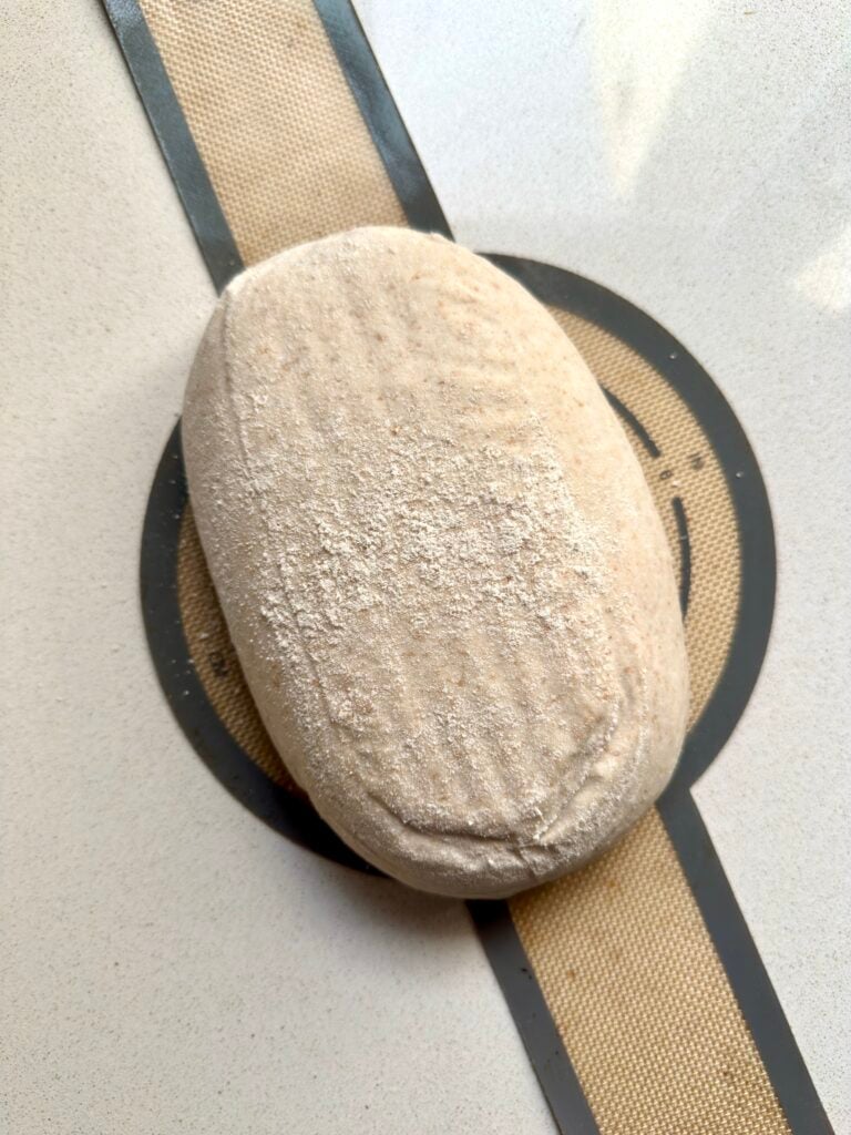 Oval sourdough loaf on a silicone bread sling.
