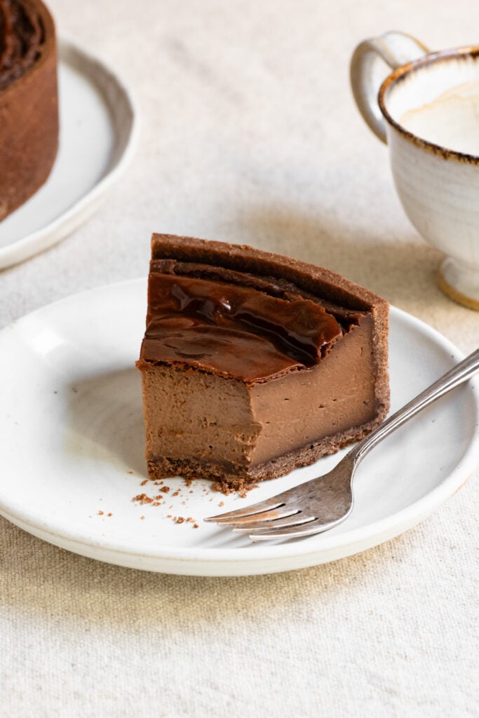 Slice of French chocolate flan on a plate with a bite missing.