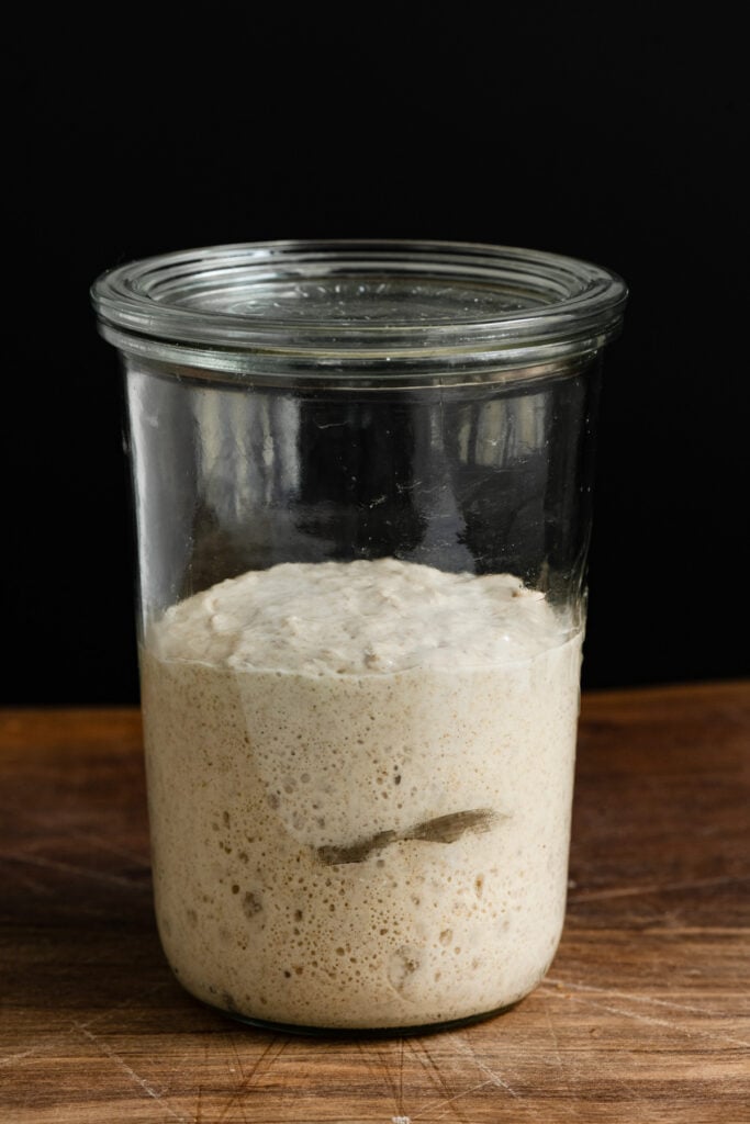 Straight on view of sourdough starter in a clear mason jar.