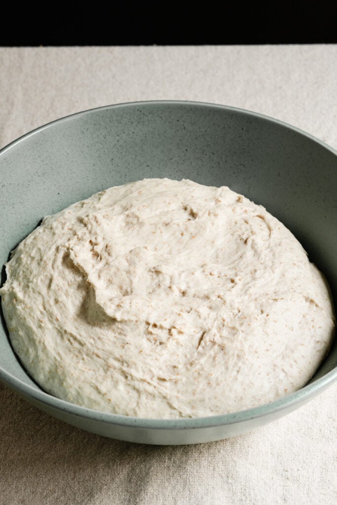 Bowl of sourdough dough on a table.