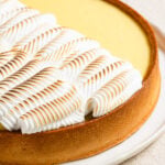 Closeup of a lemon curd tart topped with toaste dmeringue.