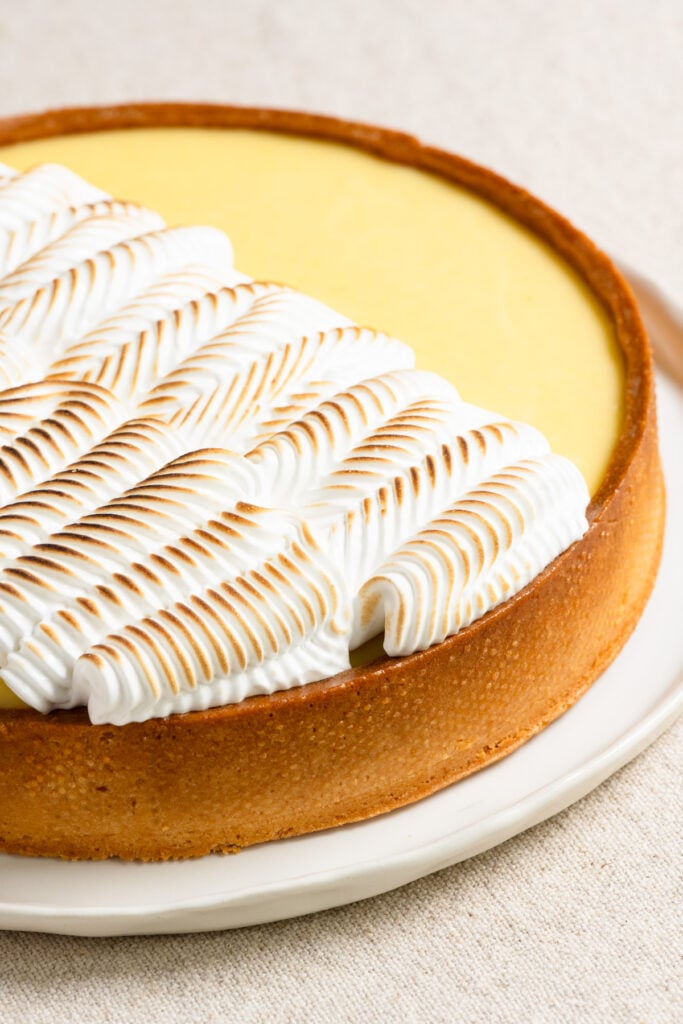 Closeup of a lemon curd tart topped with toaste dmeringue.