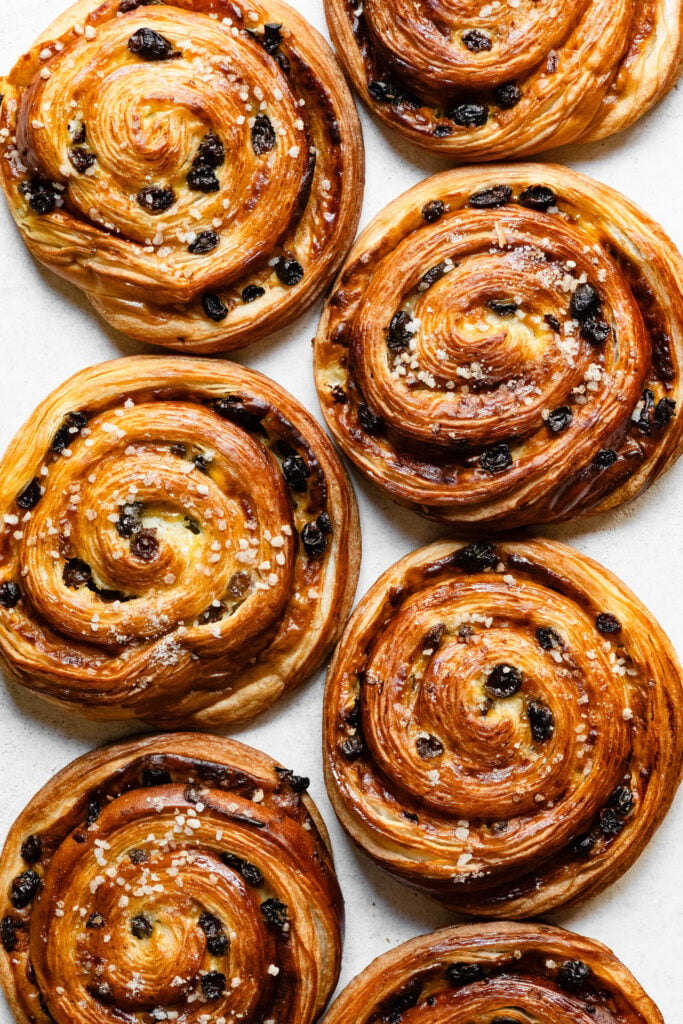 Overhead of pain au raisins topped with pearl sugar.